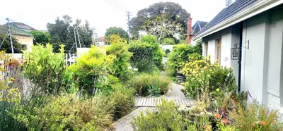 a garden on the side of a house at Tranquil Holiday Home with Pool & Garden 4 bedrooms in Cape Town