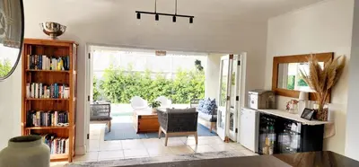 a kitchen with a dining room with a table and chairs at Tranquil Holiday Home with Pool & Garden 4 bedrooms in Cape Town