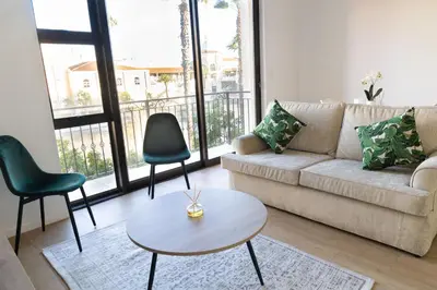 a living room with a couch and chairs and a table at Island Club Apartment in Cape Town