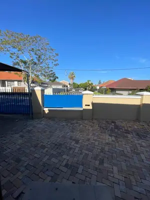 a blue fence and a brick patio with a blue wall at Lookout 12 Duminy Guesthouse in Avondale