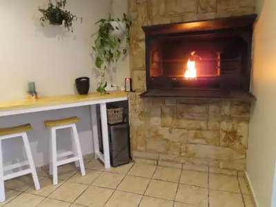 a fireplace in a room with a counter and stools at AquaPalms Hideaway - Family Friendly Pool & Hot Tub in Cape Town
