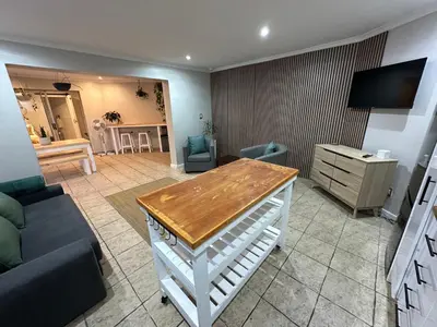 a living room with a couch and a table at AquaPalms Hideaway - Family Friendly Pool & Hot Tub in Cape Town