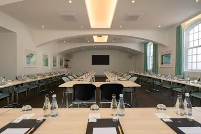 a large room with tables and chairs and a screen at The Marine Hermanus in Hermanus