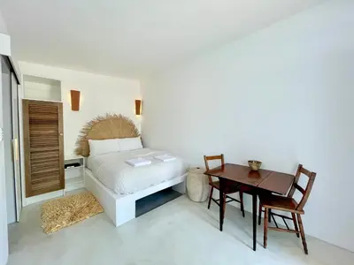a bedroom with a bed and a wooden table at Spekboom in West Beach in Cape Town