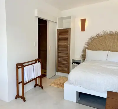 a bedroom with a large bed with a wooden headboard at Spekboom in West Beach in Cape Town
