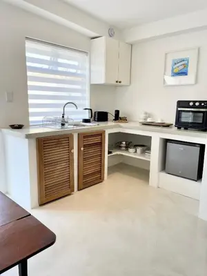 a kitchen with a sink and a microwave at Spekboom in West Beach in Cape Town