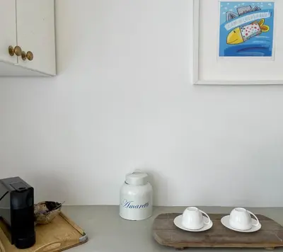 a kitchen counter with a coffee maker and a cutting board at Spekboom in West Beach in Cape Town