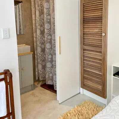a bedroom with a door leading into a room with a bed at Spekboom in West Beach in Cape Town