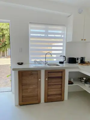 a kitchen counter with a sink and a window at Spekboom in West Beach in Cape Town