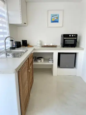 a kitchen with a sink and a microwave at Spekboom in West Beach in Cape Town