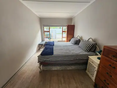 a bedroom with a bed in a room with a window at 51 on 6th in Hermanus