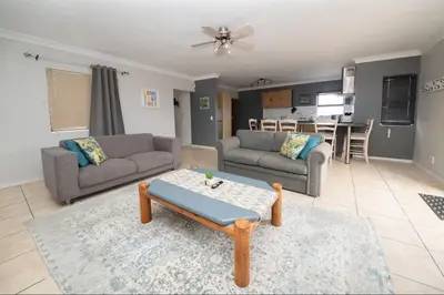 a living room with two couches and a table at Units on 8Wingerd in Somerset West