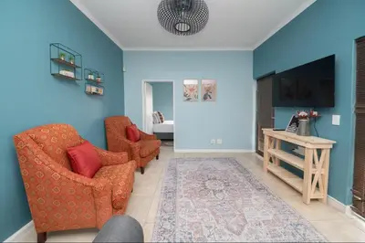 a living room with two chairs and a table at Units on 8Wingerd in Somerset West