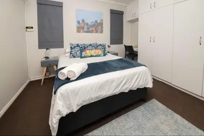 a bedroom with a large bed with towels on it at Units on 8Wingerd in Somerset West