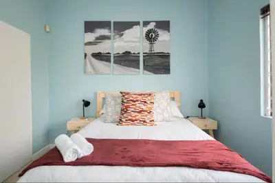 a bedroom with a bed with a red blanket at Units on 8Wingerd in Somerset West