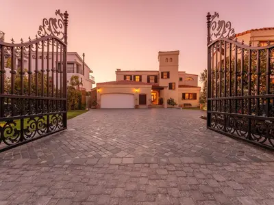 a driveway with a gate in front of a house at Luxury beachfront villa Cape Town - Sunset Beach in Cape Town
