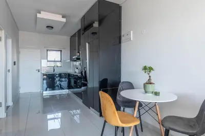 a kitchen and dining room with a table and chairs at Greystone Serenity 2-Bedroom Apartment in Cape Town