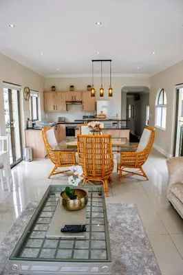 a living room with a table and chairs and a kitchen at Majorca Apartments by BON Hotels in Cape Town