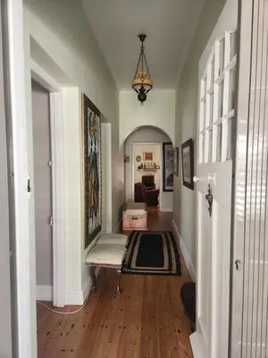 a hallway with a room with a couch and a table at Strand Beach House in Strand