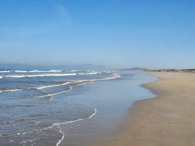 a beach with waves coming in from the ocean at Strand Beach House in Strand