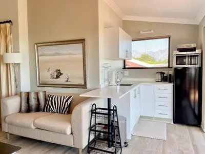 a living room with a couch and a kitchen at Dream Views in Somerset West