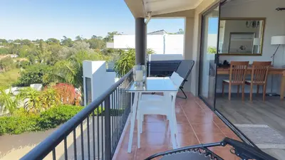 a balcony with a table and a dining table on it at Dream Views in Somerset West