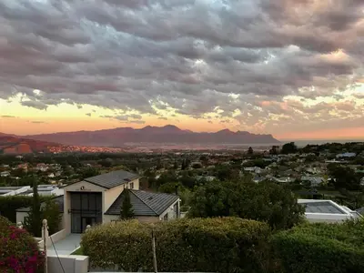 a view of a city at sunset with a house at Dream Views in Somerset West