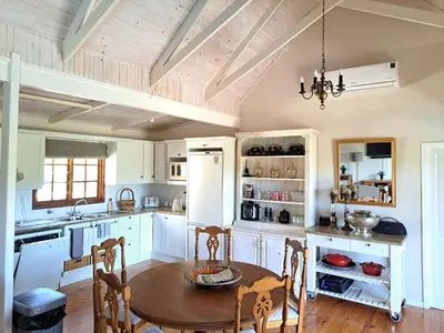 a kitchen with white cabinets and a wooden table at Glengarry in Grabouw