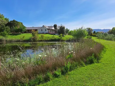 a house on a hill next to a pond at Glengarry in Grabouw