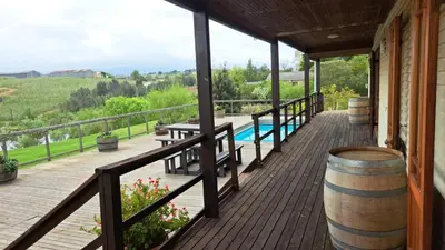 a wooden porch with a pool and a barrel at Glengarry in Grabouw