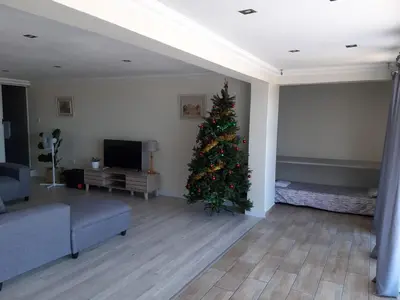 a christmas tree in a living room with a couch at Cottage on Abelia in Helderberg