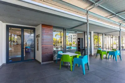 a patio with tables and chairs and windows at The Sandown 178 by CTHA in Cape Town