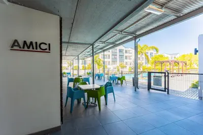 a restaurant with tables and chairs on a balcony at The Sandown 178 by CTHA in Cape Town