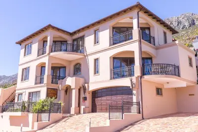 a large house with balconies and a driveway at Blue Horizon Guest House in Gordonʼs Bay