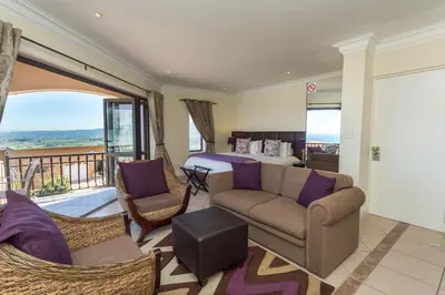 a hotel room with a bed and a couch and chairs at Blue Horizon Guest House in Gordonʼs Bay