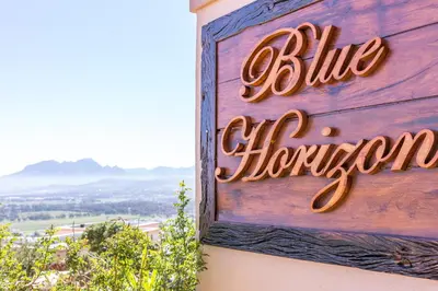 a sign for a blue horizons sign on a building at Blue Horizon Guest House in Gordonʼs Bay