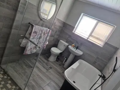 a bathroom with a shower and a toilet and a sink at Remmy Place in Hawston