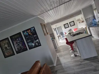 a kitchen with a counter and posters on the wall at Remmy Place in Hawston