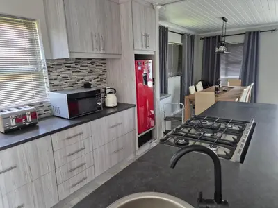 a kitchen with a stove and a red refrigerator at Remmy Place in Hawston