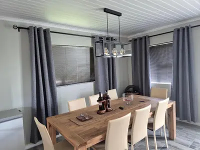 a dining room with a wooden table and chairs at Remmy Place in Hawston