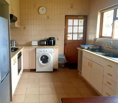 a kitchen with a washing machine and a washer at Happidaze in Hermanus