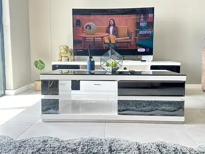 a living room with a tv on top of a table at Beach Front in Cape Town