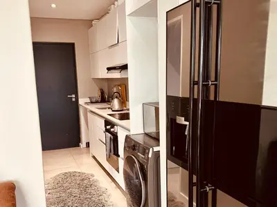 a kitchen with a refrigerator and a washer and dryer at Beach Front in Cape Town