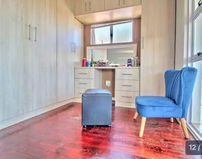 a living room with a blue chair and a ottoman at S&R Guesthouse in Cape Town