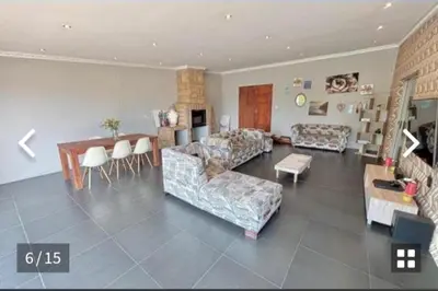 a living room with a couch and a table and chairs at S&R Guesthouse in Cape Town