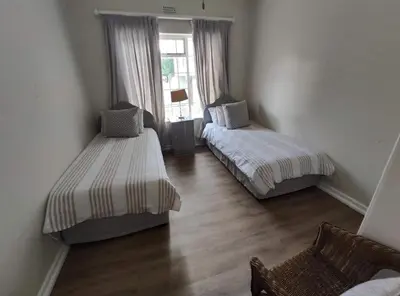 a room with two beds and a window at Voëlklip House - Home with Pool & Mountain views in Hermanus