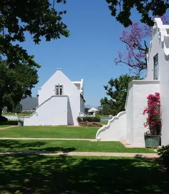 a white house with flowers on the lawn at Adara Palmiet Valley Luxurious Boutique Farm Hotel in Paarl