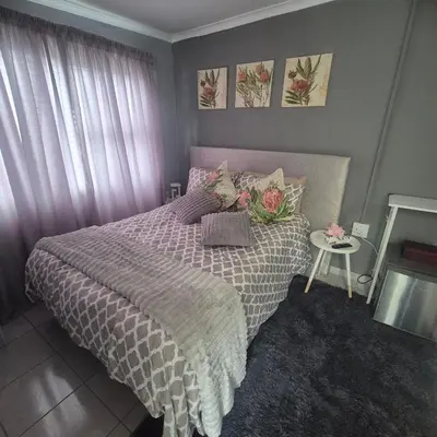 a bedroom with a bed and a table at White Lilly