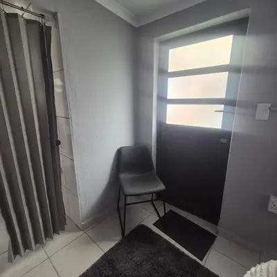 a small bathroom with a chair and a window at White Lilly
