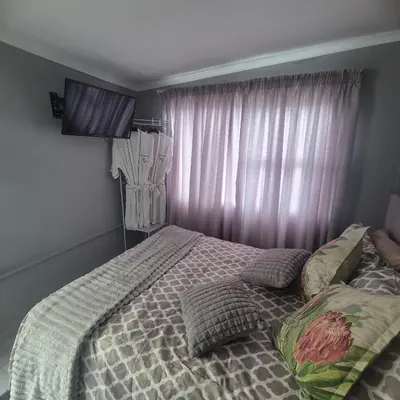 a bedroom with a bed with pillows and a window at White Lilly